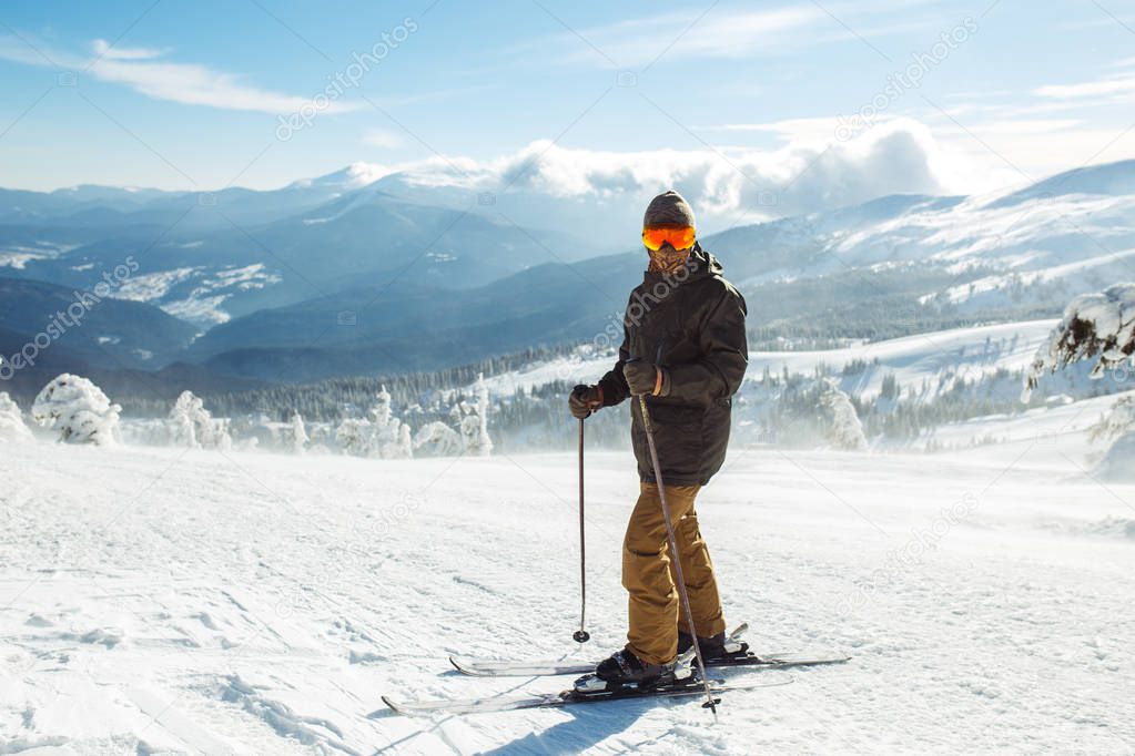 Nice man skiing in the mountains. Good skiing in the snowy mountains,  Winter is coming, first snowfall. Ski resort season is open. Ski equipment, trail.