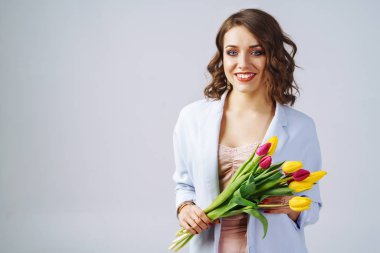 Moda fotoğraf güzel bir genç kadının onun el .o lale ile çizgiler ile güzel bir ceket ve T-shirt giymiş. Bahar kavramı. Mart 8. şık elbiseleri güzel kız