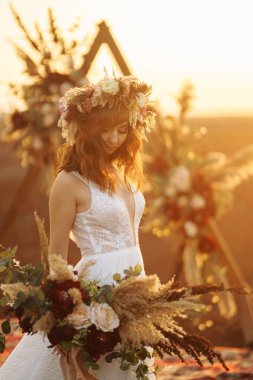 Gün batımı ışık muhteşem gelin. Güzel gelin. Boho tarzı. Gelin giyiyor moda gelinlik tüylü lüks zevk makyaj ve saç modeli ile.