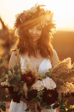 Gün batımı ışık muhteşem gelin. Güzel gelin. Boho tarzı. Gelin giyiyor moda gelinlik tüylü lüks zevk makyaj ve saç modeli ile.