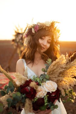 Gün batımı ışık muhteşem gelin. Güzel gelin. Boho tarzı. Gelin giyiyor moda gelinlik tüylü lüks zevk makyaj ve saç modeli ile.