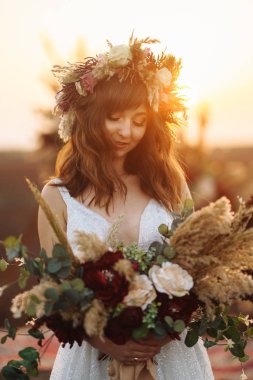 Gün batımı ışık muhteşem gelin. Güzel gelin. Boho tarzı. Gelin giyiyor moda gelinlik tüylü lüks zevk makyaj ve saç modeli ile.