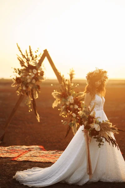 惊人的新娘在日落的光 漂亮的新娘博霍风格 新娘穿着时尚婚纱礼服与羽毛与豪华喜悦化妆和发型 — 图库照片