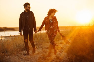 Birlikte eğleniyoruz. Tarz sahibi ve sevgi dolu bir çift deniz kenarında eğleniyor. Çift genç ve aşıklar. Gençlik, aşk ve yaşam tarzı kavramı. Güzel bir yaz gününde gün batımı.