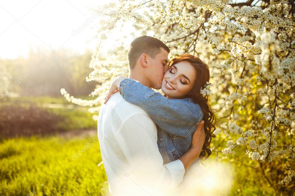 Beautiful loving couple in the blooming gardens. Wedding concept. Great sunset light. Lovely newlyweds.