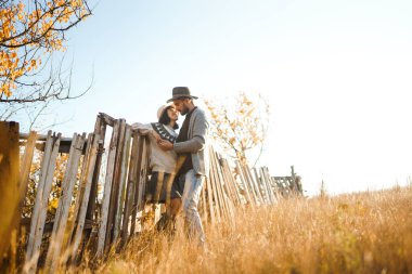 Güzel hipster çift birbirlerine bakıyor. Güzel şapkalar ve kazaklar giyen bir çift. Yaşam tarzı, parkta güneşli bir günde iki oyun mutlu çift. Gençlik, sevgi ve yaşam tarzı kavramı. Sonbaharda gün batımı 