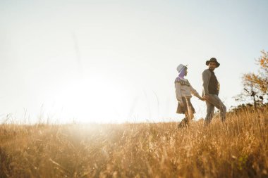 Güzel hipster çift birbirlerine bakıyor. Güzel şapkalar ve kazaklar giyen bir çift. Yaşam tarzı, parkta güneşli bir günde iki oyun mutlu çift. Gençlik, sevgi ve yaşam tarzı kavramı. Sonbaharda gün batımı 