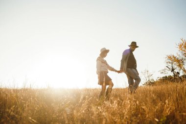 Güzel hipster çift birbirlerine bakıyor. Güzel şapkalar ve kazaklar giyen bir çift. Yaşam tarzı, parkta güneşli bir günde iki oyun mutlu çift. Gençlik, sevgi ve yaşam tarzı kavramı. Sonbaharda gün batımı 