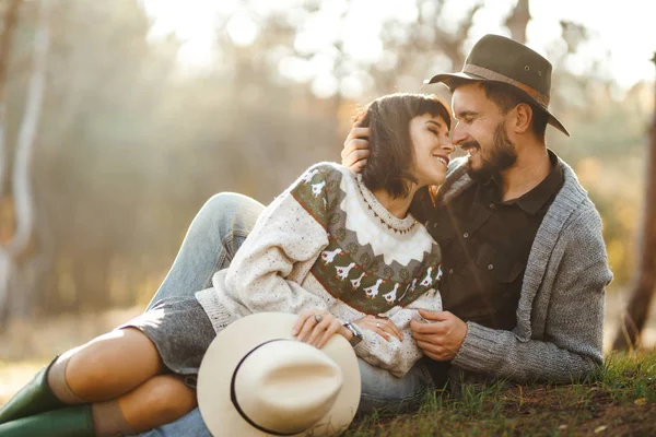사랑스러운 힙스터 부부는 서로를 아름다운 모자와 스웨터를 라이프 스타일 공원에서 — 스톡 사진
