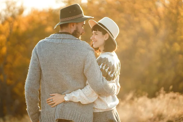 可爱的时髦夫妇看着对方 一对夫妇戴着漂亮的帽子和毛衣 生活方式 幸福的两对夫妇在阳光明媚的日子在公园里玩耍 爱情和生活方式的概念 秋天的日落 — 图库照片