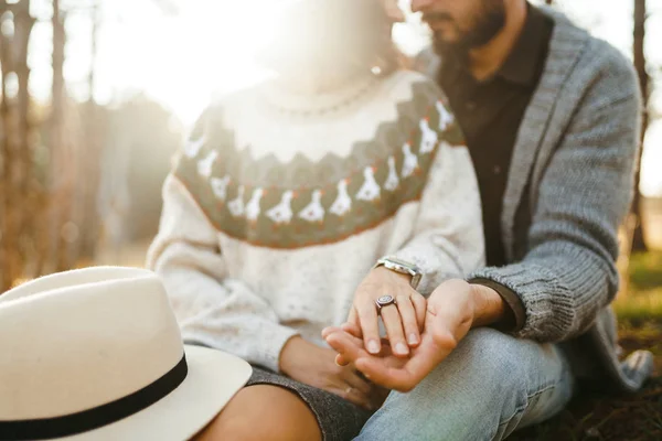 Lovely hipster couple looking at each other. Couple wearing beautiful hats and sweaters. Lifestyle, happy couple of two play on a sunny day in the park. The concept of youth, love and lifestyle. Sunset in autumn