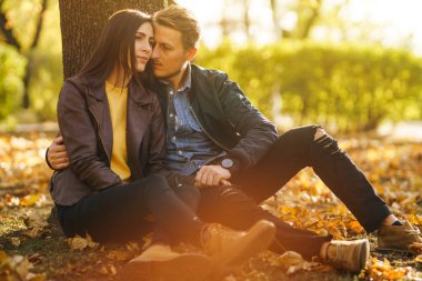 Güzel güzel çift birbirlerinin tadını çıkarıyorlar. Güzel sonbahar günü. Yaşam tarzı, parkta güneşli bir günde iki oyun mutlu çift. Gençlik, sevgi ve yaşam tarzı kavramı.