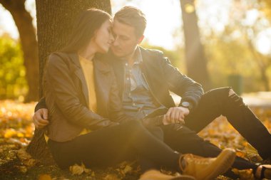 Güzel güzel çift birbirlerinin tadını çıkarıyorlar. Güzel sonbahar günü. Yaşam tarzı, parkta güneşli bir günde iki oyun mutlu çift. Gençlik, sevgi ve yaşam tarzı kavramı.
