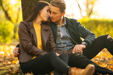 Güzel güzel çift birbirlerinin tadını çıkarıyorlar. Güzel sonbahar günü. Yaşam tarzı, parkta güneşli bir günde iki oyun mutlu çift. Gençlik, sevgi ve yaşam tarzı kavramı.