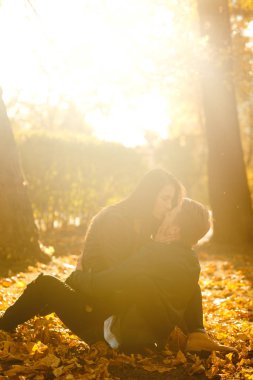 Güzel güzel çift birbirlerinin tadını çıkarıyorlar. Güzel sonbahar günü. Yaşam tarzı, parkta güneşli bir günde iki oyun mutlu çift. Gençlik, sevgi ve yaşam tarzı kavramı.