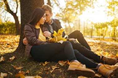 Güzel güzel çift birbirlerinin tadını çıkarıyorlar. Güzel sonbahar günü. Yaşam tarzı, parkta güneşli bir günde iki oyun mutlu çift. Gençlik, sevgi ve yaşam tarzı kavramı.