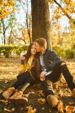 Güzel güzel çift birbirlerinin tadını çıkarıyorlar. Güzel sonbahar günü. Yaşam tarzı, parkta güneşli bir günde iki oyun mutlu çift. Gençlik, sevgi ve yaşam tarzı kavramı.