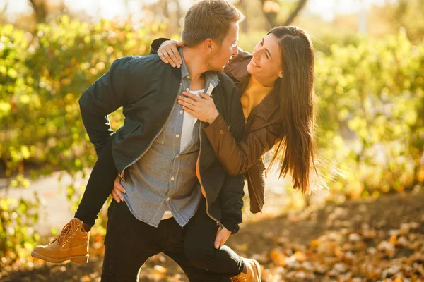 Lovely beautiful couple enjoying each other.  Beautiful autumn day. Lifestyle, happy couple of two play on a sunny day in the park. The concept of youth, love and lifestyle.