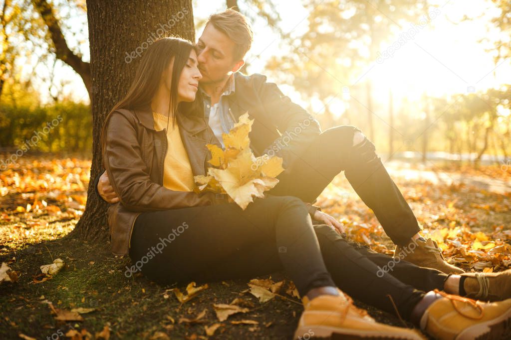 Lovely beautiful couple enjoying each other.  Beautiful autumn day. Lifestyle, happy couple of two play on a sunny day in the park. The concept of youth, love and lifestyle.