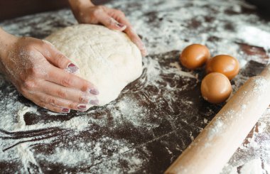 Ahşap masa arkasında kadın eli ile para kazanmak. Yemek pişirme konsepti. Güzel kadın elleri.