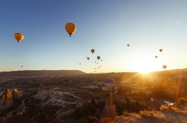 Sıcak Hava Balonu Uçuşu Güney Kapadokya Turu Goreme Açık Hava Müzesi. Güneş doğarken yükselen sıcak hava balonları Kapadokya 'da. Goreme Milli Parkı Türkiye.