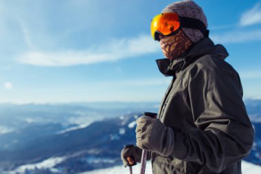 Dağlarda kayak yapan genç bir adam. Karlı dağlarda kayak yaparken, kış geliyor, kar yağıyor. Kışın aktif bir yaşam tarzı. Kayak merkezi sezonu açıldı. Kayak ekipmanları, patika. Olağanüstü kış sporları.