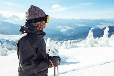 Dağlarda kayak yapan genç bir adam. Karlı dağlarda kayak yaparken, kış geliyor, kar yağıyor. Kışın aktif bir yaşam tarzı. Kayak merkezi sezonu açıldı. Kayak ekipmanları, patika. Olağanüstü kış sporları.