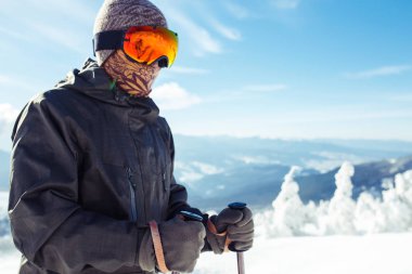 Dağlarda kayak yapan genç bir adam. Karlı dağlarda kayak yaparken, kış geliyor, kar yağıyor. Kışın aktif bir yaşam tarzı. Kayak merkezi sezonu açıldı. Kayak ekipmanları, patika. Olağanüstü kış sporları.