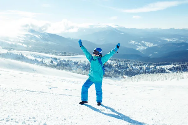 一个年轻的女孩喜欢冬季美景 一个穿着冬衣 头戴蓝色头盔 身穿夹克的漂亮姑娘在山里度过了一段美好的时光 自然的概念 — 图库照片