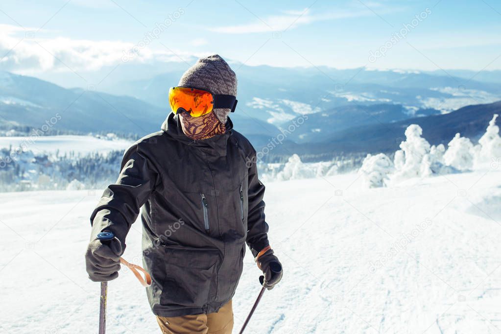 Nice young man skiing in the mountains. Skiing in the snowy mountains, Winter is coming, snowfall. Active lifestyle in winter. Ski resort season is open. Ski equipment, trail. Extreme winter sports.