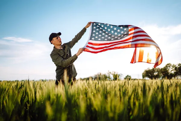 7月4日在战场上拿着美国国旗的爱国人士 年轻人自豪地挥舞着美国国旗 独立日 — 图库照片