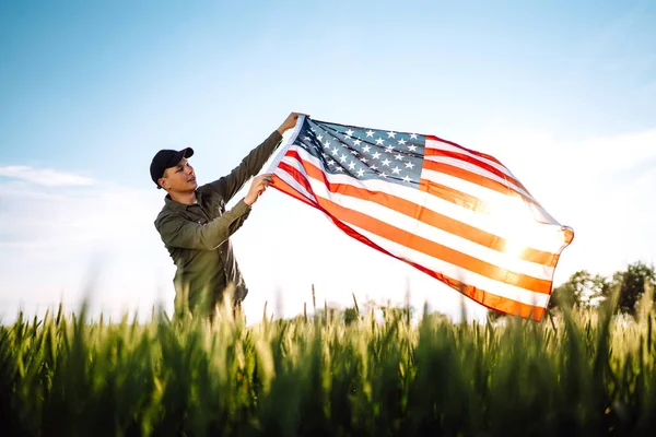 7月4日在战场上拿着美国国旗的爱国人士 年轻人自豪地挥舞着美国国旗 独立日 — 图库照片