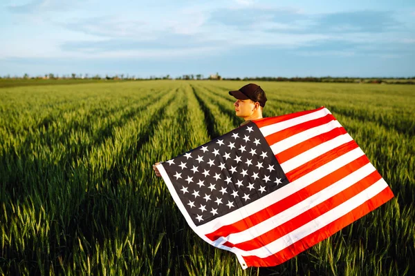 年轻人自豪地举着美国国旗 爱国者在蓝天下升起美国国旗 独立日 7月4日 — 图库照片