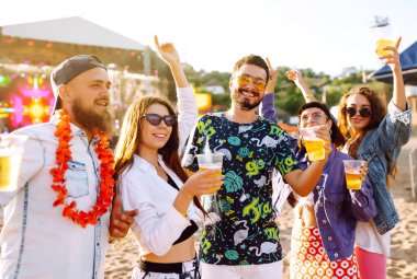 Bira dansı yapan ve müzik festivalinde eğlenen bir grup arkadaş. Yaz plajı partisi, tatil, tatil konsepti. Gençlik ve kutlama konsepti..