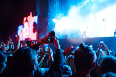 Canlı müzik festivalinde konser sahnesinin fotoğrafını çeken akıllı telefon kayıtları. Gençlik, parti, tatil konsepti.