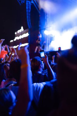 Canlı müzik festivalinde konser sahnesinin fotoğrafını çeken akıllı telefon kayıtları. Gençlik, parti, tatil konsepti.