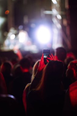 Canlı müzik festivalinde konser sahnesinin fotoğrafını çeken akıllı telefon kayıtları. Gençlik, parti, tatil konsepti.
