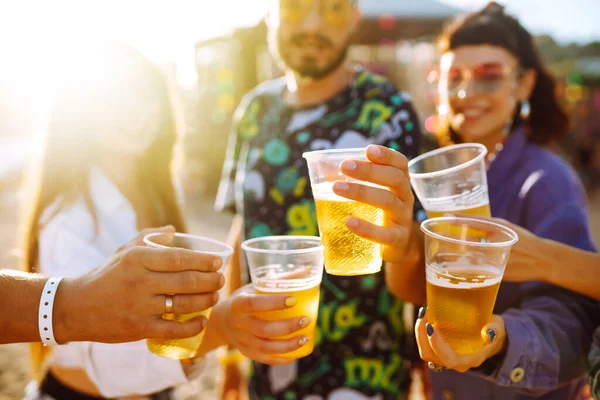 Group of friends with beer dancing and having fun at music festival together. Summer Beach party, holiday, vacation concept.Youth and celebration concept.