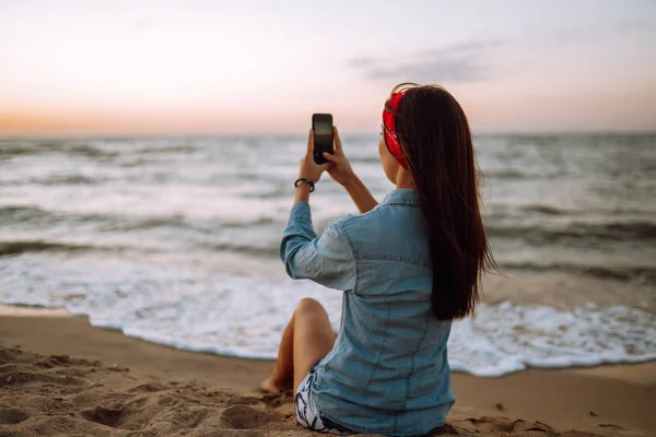 Sahilde Oturan Genç Kız Gün Batımında Denizin Fotoğraflarını Çekiyor Tatildeki — Stok fotoğraf