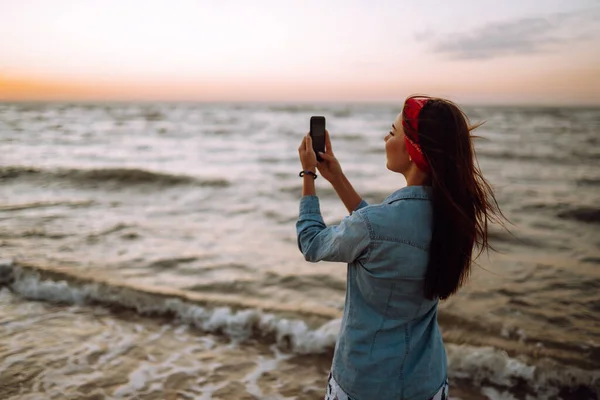 Sahilde Oturan Genç Kız Gün Batımında Denizin Fotoğraflarını Çekiyor Tatildeki — Stok fotoğraf