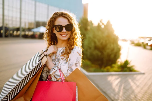 買い物中の女性 ショッピングの後に街を歩くカラフルなショッピングバッグを持つ若い女の子 消費主義 ショッピング ライフスタイルの概念 — ストック写真