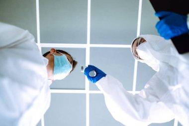 Hastalık kontrol uzmanı alnındaki sıcaklığı ölçmek için kızılötesi termometre cihazı kullanıyor. Covid-19, karantina veya virüs salgını kavramı.