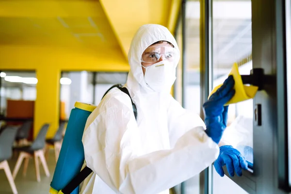 Covid 사무실을 청소하고 보호용 양복을 마스크를 탈수증자는 사무실 살균제를 바이러스 — 스톡 사진