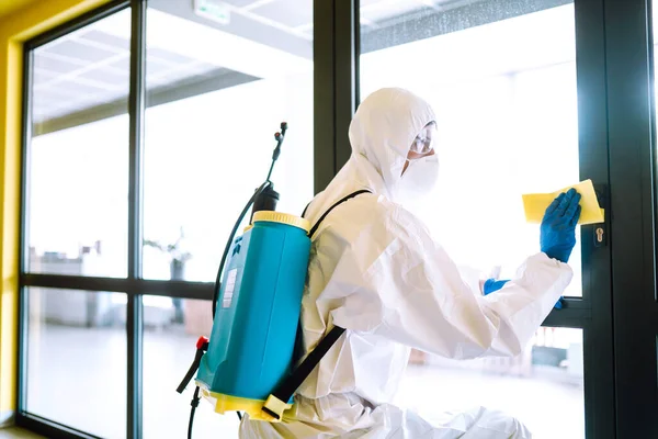 Covid 사무실을 청소하고 보호용 양복을 마스크를 탈수증자는 사무실 살균제를 바이러스 — 스톡 사진