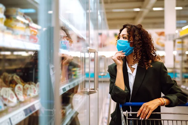 年轻女人戴着面具在超级市场买东西 在流行病检疫期间购物 Covid 2019 — 图库照片