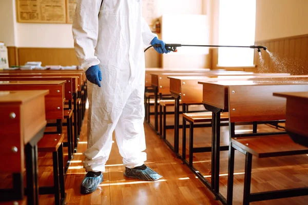 Een Man Een Beschermend Pak Desinfecteert Schoolklas Met Spuitchemicaliën Verspreiding — Stockfoto