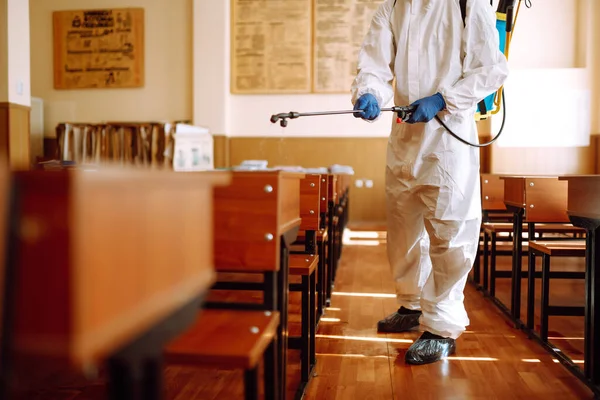 Een Man Een Beschermend Pak Desinfecteert Schoolklas Met Spuitchemicaliën Verspreiding — Stockfoto