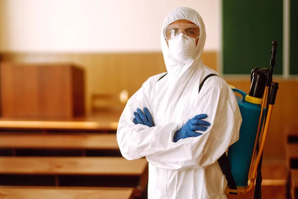 穿着防护服 用喷雾化学品消毒学校班级的人的画像 Covid — 图库照片