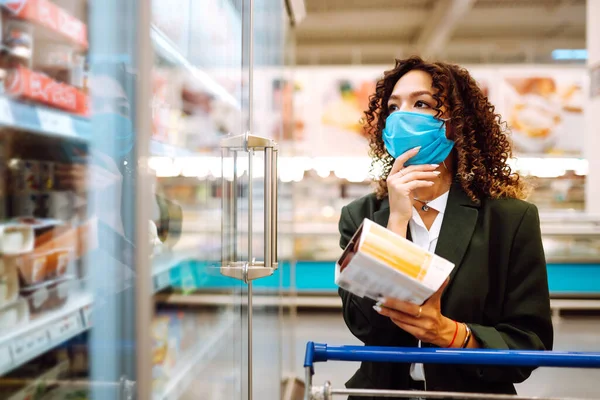 年轻姑娘戴着口罩在超市买东西 在Coronavirus的恐慌购物 Covid 2019 — 图库照片