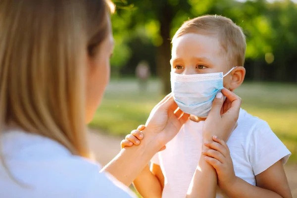 Mother Puts Her Baby Sterile Medical Mask Park Pandemic Covid — Stock Photo, Image